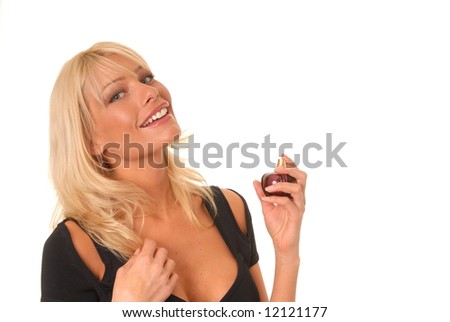Lovely blond girl applying perfume from a perfume bottle