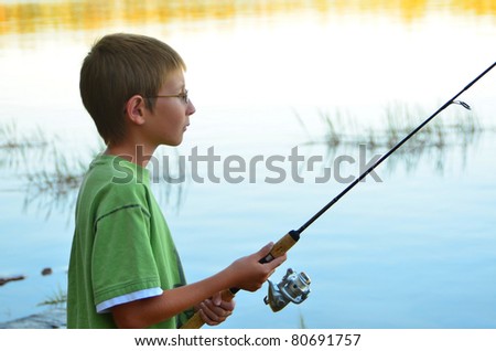 Young boy fishing in a forest lake