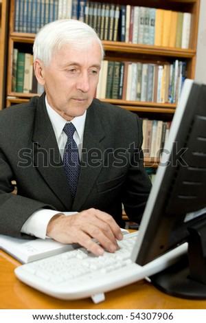 Elderly man peers into monitor of the computer