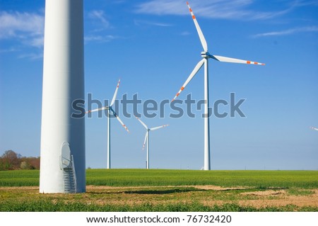 Clean energy. Windmills on green field.