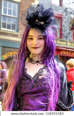 WHITBY, ENGLAND - APRIL 27: Happy smiling teenage girl in Goth costume and make-up is participant at Whitby Gothic Weekend one of the most popular Gothic events in the world.  Whitby 27, April 2013.