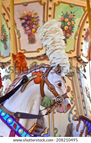 Portrait of a brightly decorated carousel pony with plumage headgear.