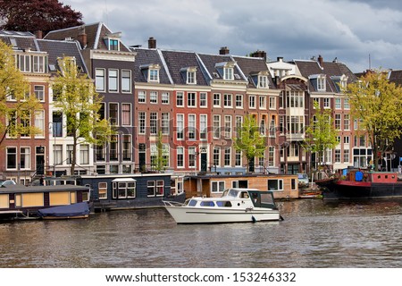Amsterdam river view, houses and houseboats on the Amstel river in Netherlands, North Holland province.