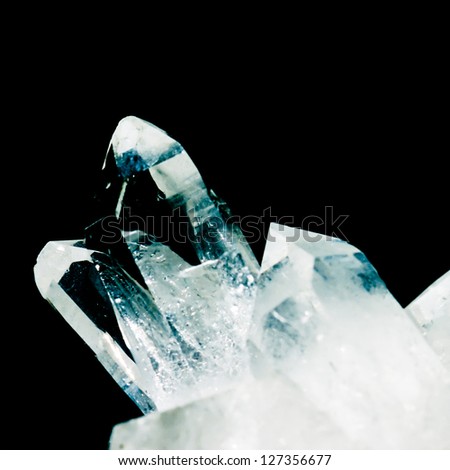 Cluster of rock crystals or pure quartz, a clear macrocrystalline variety of silica (SiO2) isolated on black background. This gemstone is said to have strong healing power. Birthstone for April.