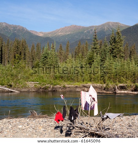Drying clothes on river bank in pristine wilderness landscape, Big Salmon River, Yukon Territory, Canada
