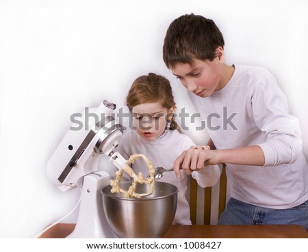 Little girl and her big brother mixing up cookie dough.
