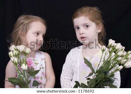 Three and four year old sisters with flowers