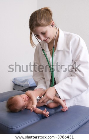 Young female doctor listening to a baby\'s heart.