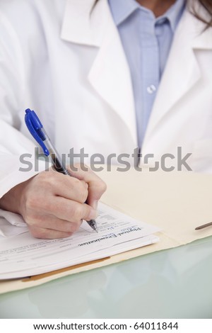 Doctor taking notes in a patient chart, close-up view.