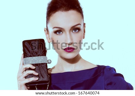 face of brunette woman with fashion makeup and red lips holding purse Ã¢Â?Â?light blue background