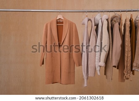 Row of different brown and warm knitted on hanger autumn, jacket, coat winter clothes-wooden background

 Сток-фото © 