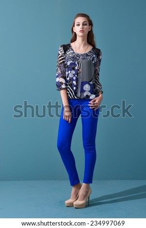 Full picture of casual young woman in blue jeans posing on light background