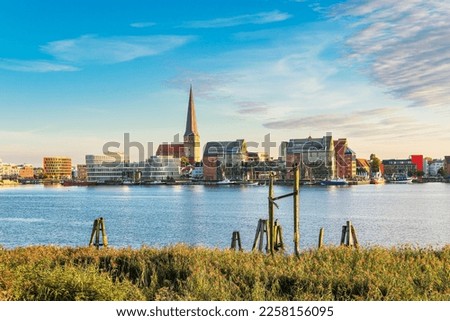 Image, Stock Photo View over the Warnow river to the city of Rostock in the evening