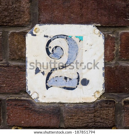 weathered house number two on a metal plate