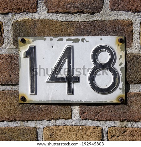 house number one hundred and forty eight, embossed in a metal plate