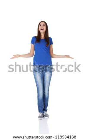 Surprised teen girl with outstretched arms looking up on copy space. Isolated on white.