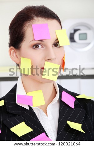 Beautiful caucasian businesswoman sitting in the office with post it notes on her body.
