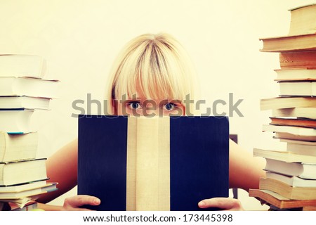 Young student woman with lots of books studying for exams.