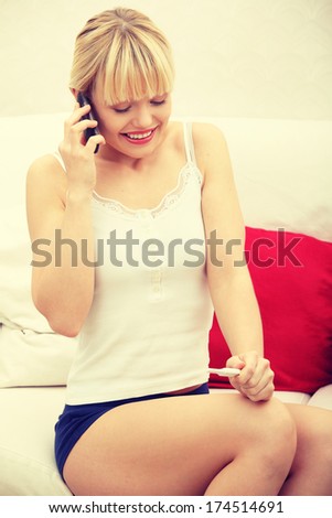 Pregnancy test - happy woman on phone, positive result