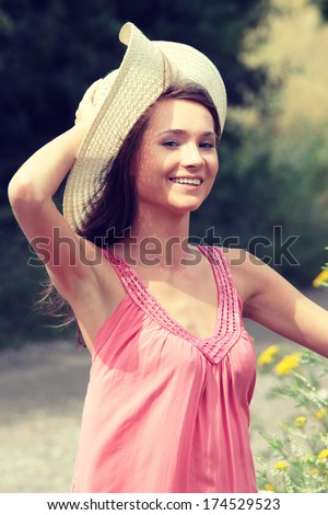 a beautiful girl in big summer hat in the country