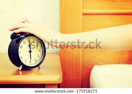 Hand reaching out for alarm clock