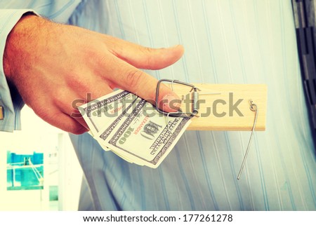 Businessman with finger in moustrap - business trap concept