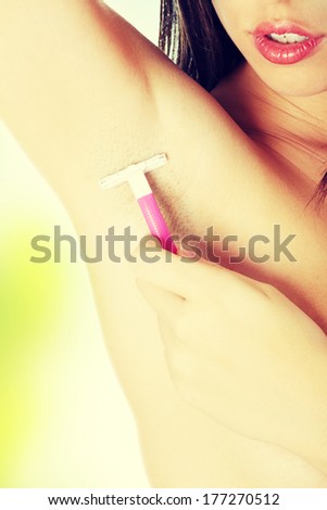 Woman shaving armpit