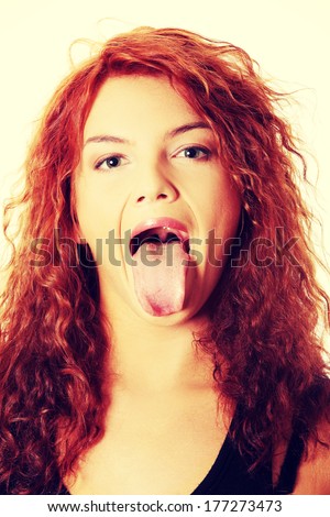 Portrait of beautiful woman who puts tongue out