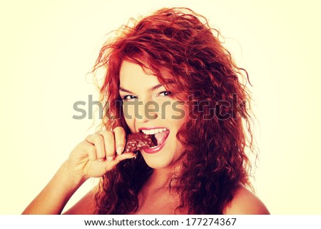 Young beautiful woman eating chocolate bar, isolated on white