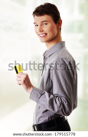 Young happy businessman holding credit card