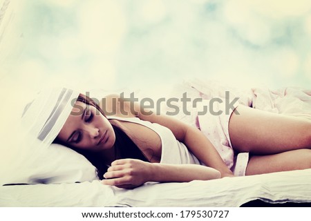 Sensual young woman laying in pink bed. Sleeping