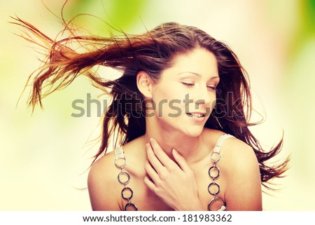 Young beautiful woman in elegant, evening, white dress dancing with wind (hair blowing)