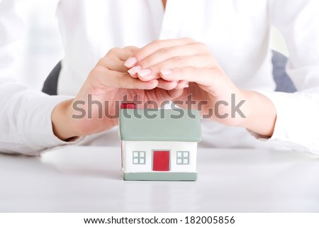 Female businesswoman hands protecting house. Home protecting concept for insurance or security