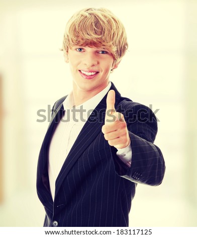 Happy young businessman pointing at you with smile