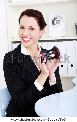 Business woman is holding hourglass, in office. Time pass concept.