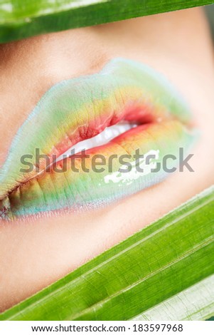 Lips covered with rainbow  colors. Close up photo.