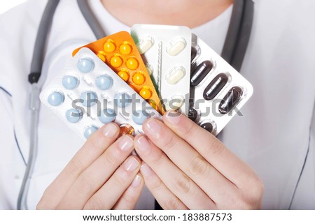 Young female doctor with pills. Isolated on white.