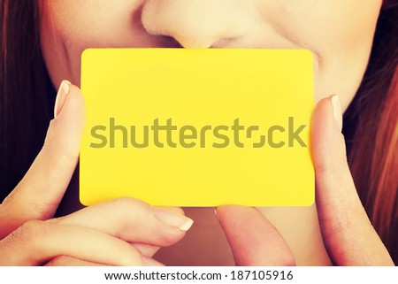 Empty yellow personal card over caucasian woman\'s face.