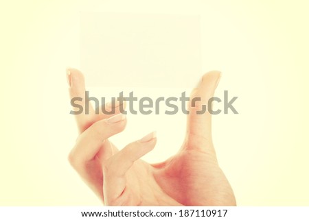 Empty, white personal card between fingers. Isolated on white.