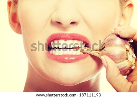 Close up on woman mouth with raw garlic.