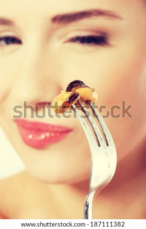 Smiling caucasian woman eating sea fruit with fork.