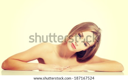 Beautiful caucasian naked woman lying on a table. Isolated on white.