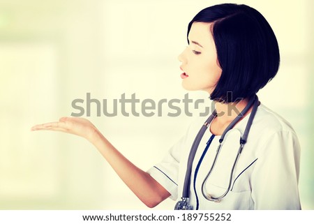 Medical doctor woman or nurse presenting and showing copy space for product or text