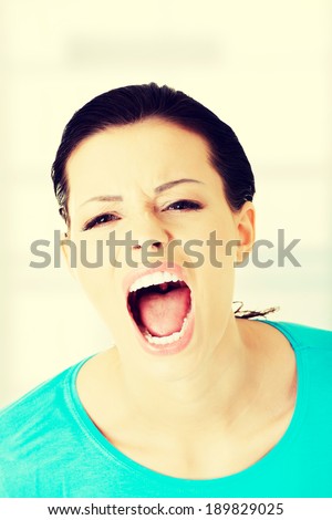 Young casual woman screaming with anger