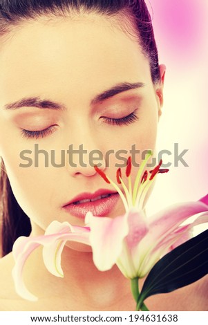 Portrait of the attractive girl without a make-up, with lily flower in hand
