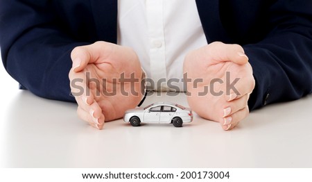 Close up on car toy model between hands lying on the table.