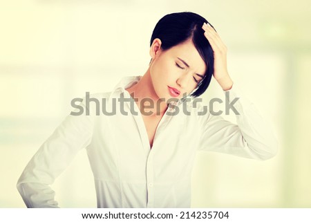 A businesswoman with a headache holding head, isolated on white background