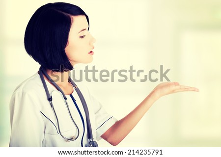 Medical doctor woman or nurse presenting and showing copy space for product or text, isolated on white background