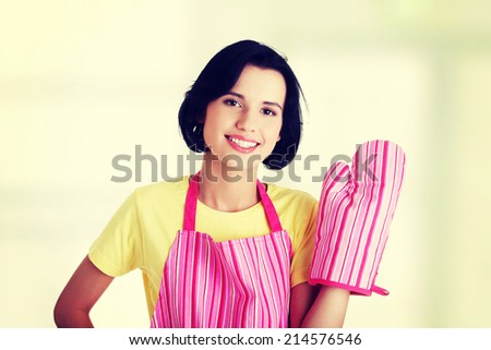 Young housewife in pink apron ang glove, isolated on white