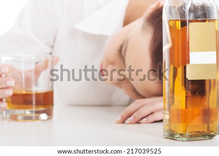 Alone young businesswoman in depression, drinking alcohol.